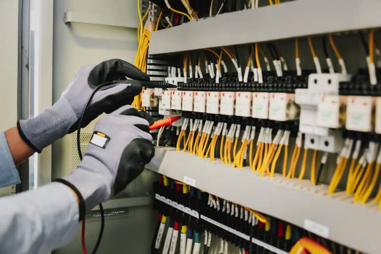 Image d'une personne effectuant des modifications sur un tableau électrique dans un ERP